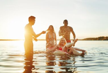 4 friends swimming in a lake on a floaty