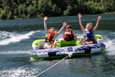 kids riding a tube on a lake having fun